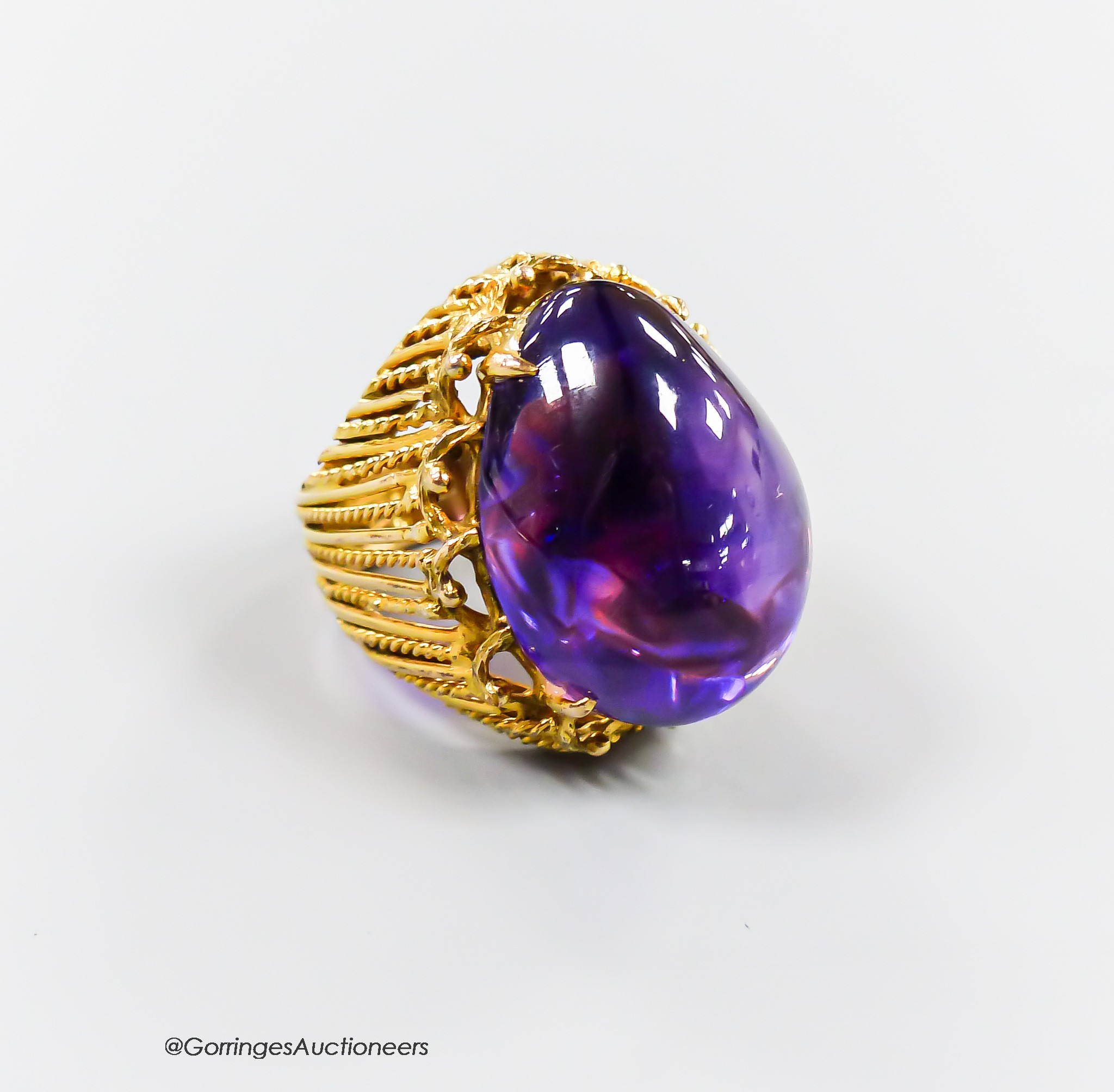 A pierced 585 yellow metal and large cabochon amethyst set dress ring, size K/L, gross 17.4 grams.